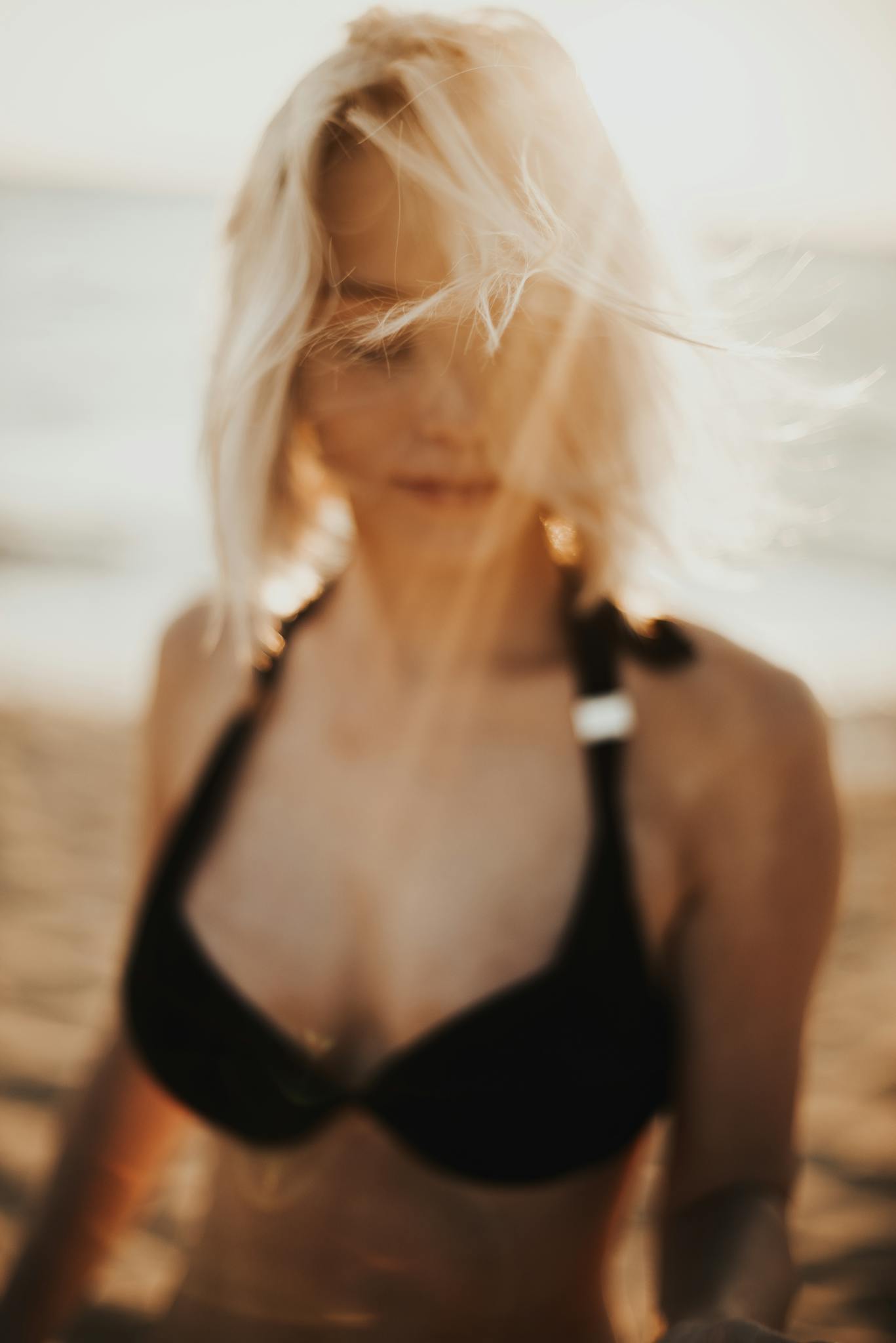 Artistic blurred shot of a woman on a beach with warm light.